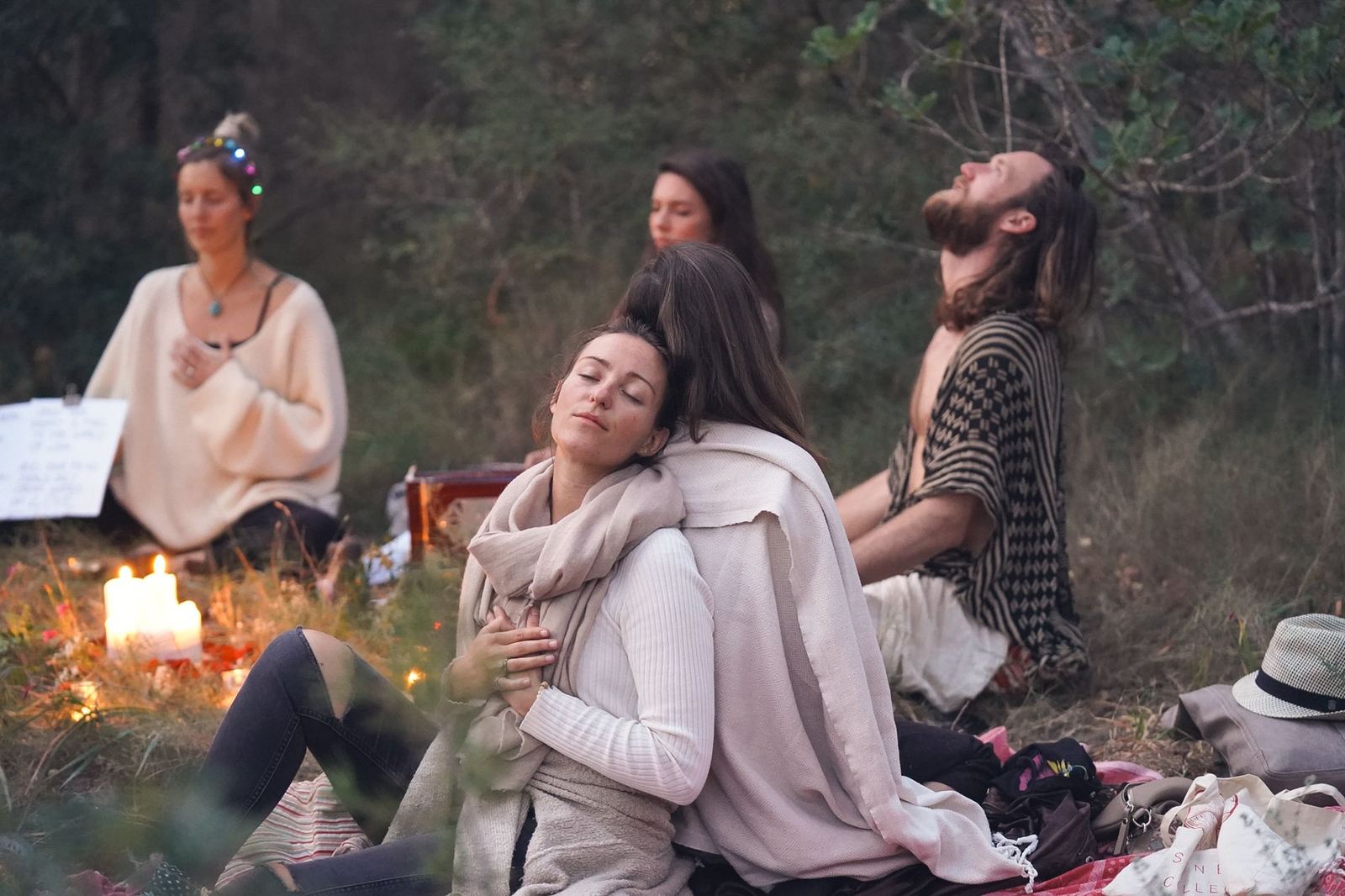 Participants of a cacao ceremony sitting together outdoors at dusk