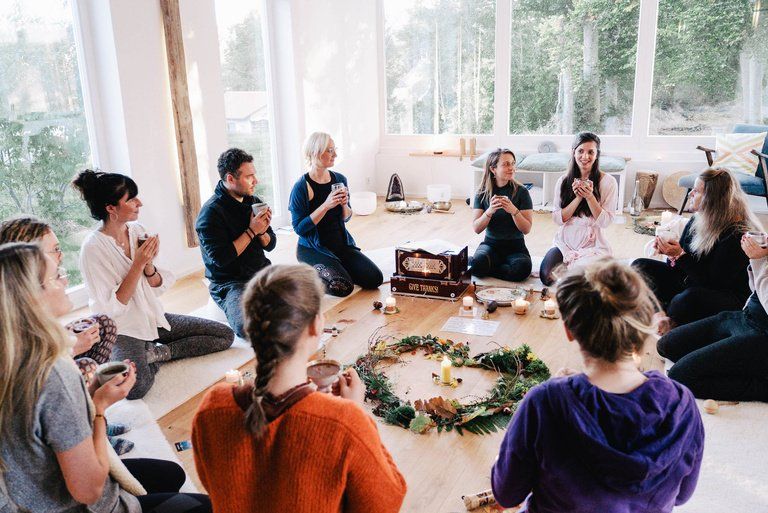 A circle of women sitting together in a bright studio